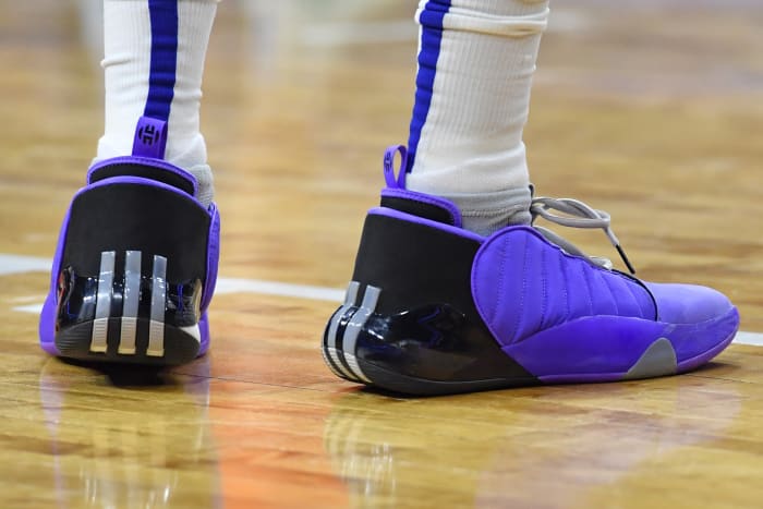 View of purple and black adidas shoes.